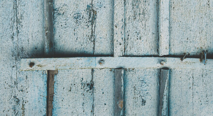 Vintage wood background texture with knots and nail holes with blue peeling paint. Empty template.