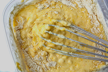 dough in bowl and whisk on white background top view