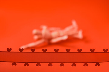 Red ribbon with hearts in focus. Couple making love out of focus. Juicy red background. Adult...