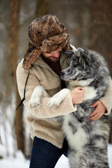 Men playing with siberian husky in winter forest and park, animals and ecology. Pet lover. Dog - human s friend concept