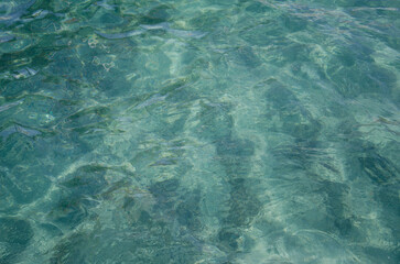 Aerial view of aquamarine sea surface. Rough sea texture. Top view natural background of rippled sea-green sea water. Marine theme with copy space.