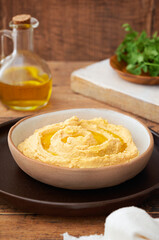 Homemade hummus with bread sticks and parsley on wooden background copy space. Selective focus.
