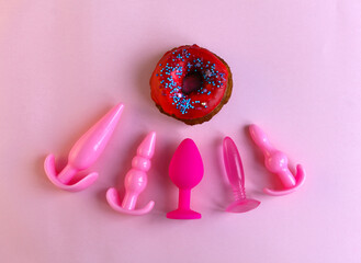 Black silicone sex toys on a pink background. Erotic toy for fun. Diffrent anal butt plugs