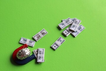 Fototapeta premium Business mindset, capitalism concept. Brain and magnet attract money on green background