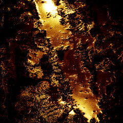 Muddy spot in an old damp tunnel with yellow light reflections.