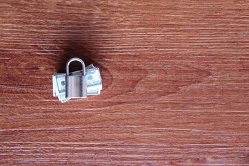 Security, financial protection and saving money concept. Stack of banknotes and padlock. Copy space.