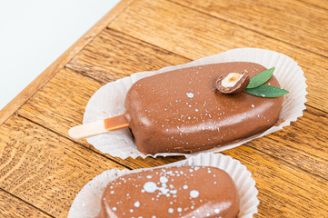 Chocolate cake pops in the form of ice cream on a stick. On a wooden stand, side view. Concept food, sweets.