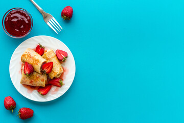 Hot rolled pancakes with strawberry and berry sauce