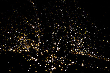 Golden and silver blurred bokeh lights on black background. Glitter sparkle stars for celebrate....