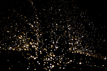 Golden and silver blurred bokeh lights on black background. Glitter sparkle stars for celebrate. Overlay for your design