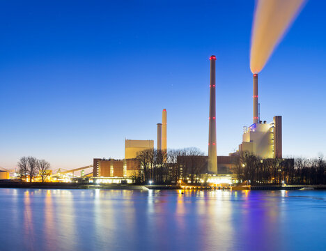 Illuminated steam power plant in the twilight
