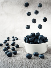 blueberries in a bowl and levitating in the air