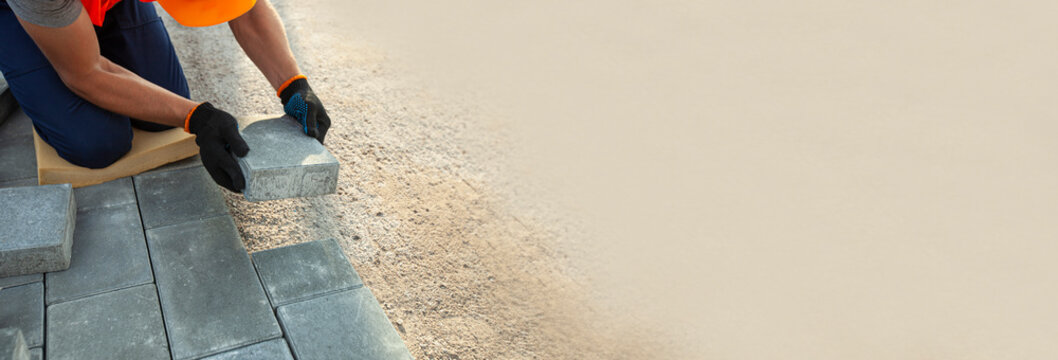 Worker lining paving slabs path