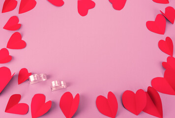 Czerwone serca i srebrne formy w kształcie serca, walentynkowe  różowe tło.