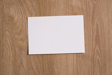 White blank piece of paper on a wooden texture background