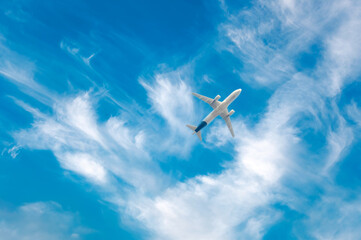 Commercial airplane flying against blue cloudscape sky. Jet plane in high flight. Airliner flying...