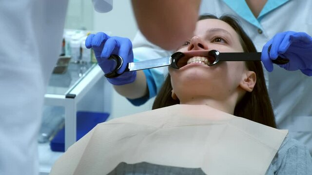 Dentist orthodontist is taking pictures of woman's teeth before treatment in dentistry. Orthodontic treatment in dentistry, dental prosthetics. Her teeth before installing veneers crowns.
