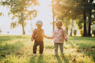 Fototapeta premium Cute little boy and girl together in autumnal park