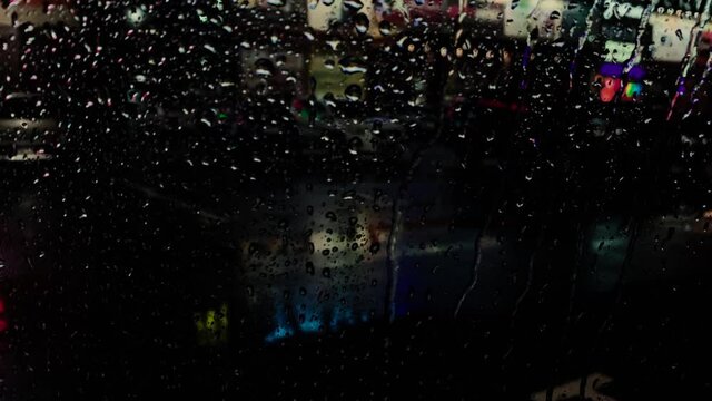 Rainy night in the parking lot of shops with colorful signs of light