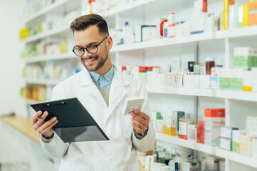 Naklejka na ściany i meble Portrait of a handsome pharmacist working in a pharmacy