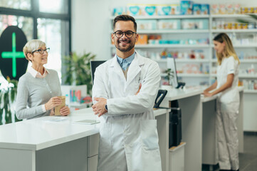 Fototapeta na wymiar Young female pharmacist posing while working in a pharmacy