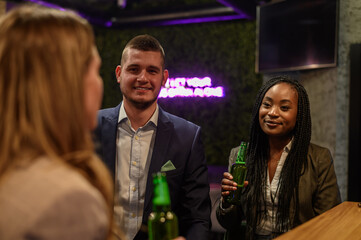 Cheerful colleagues drinking beer in the bar together after work