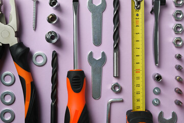 Work tools on purple background, top view