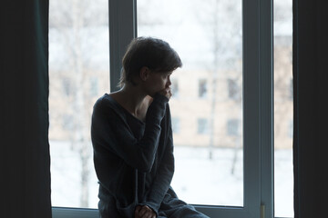 Sad stressed woman sitting alone suffering mental pain