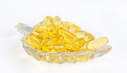 Close up van goud visolie in kom op witte achtergrond. Aanvullende voeding voor een goede gezondheid. Omega 3. Vitamine E. Capsules zalmvisolie.