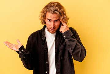 Young caucasian man isolated on yellow background showing a disappointment gesture with forefinger.