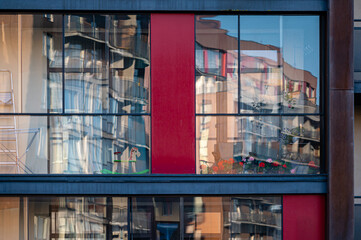 modern apartment building wall with large windows close-up, reflections in the glass
