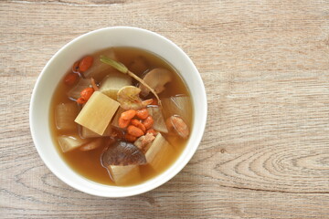 boiled radish with dry shrimp and black mushroom topping goji berry in ginger soup on bowl