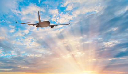 White passenger airplane flying in the sky amazing clouds in the background - Travel by air transport