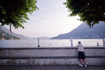 Vacation in Italy. Man enjoying the view on the promenade of Como Lake.