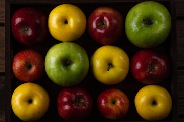 Colorful apples. Red, yellow and green apples on a wooden tray
