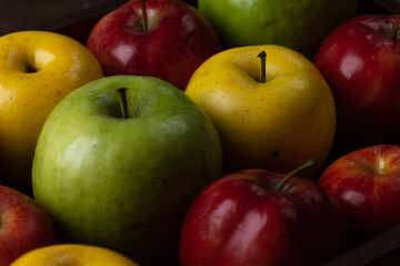 Colorful apples. Red, yellow and green apples on a wooden tray