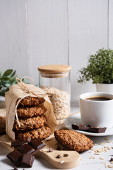 A cup of coffee in the foreground. Selective focus. Against the background of oatmeal cookies