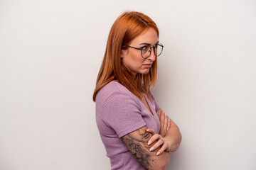 Young caucasian woman isolated on white background suspicious, uncertain, examining you.