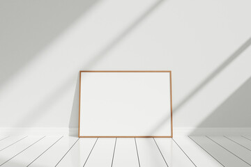 Minimalist and clean horizontal wooden poster or photo frame mockup on the floor leaning against...
