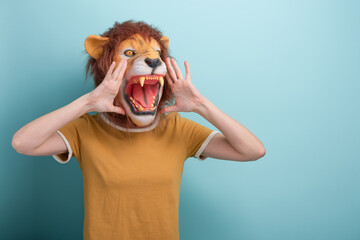 Young woman in lion mask holding hands near her open mouth, making loud announcement , isolated on...