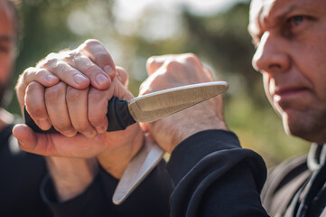 Knife vs knife fight. Kapap instructors demonstrates sombrada drill training