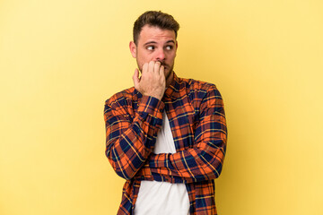 Young caucasian man isolated on yellow background biting fingernails, nervous and very anxious.