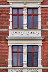 Klassizistische Fassadengestaltung an einem denkmalgeschützten Wohn- und Gesachäftshaus in Guben. Inschrift: "Anno 1891"