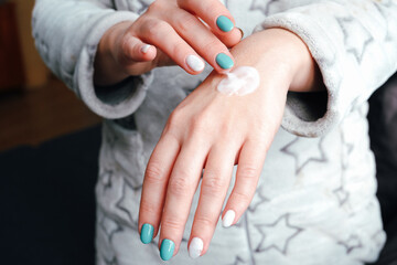 Hand skin care, cosmetology concept. Woman applying hand cream after bathing. Close-up on hands