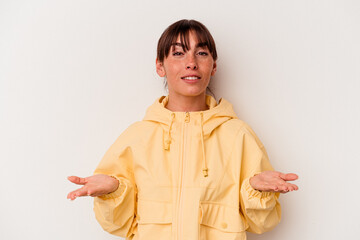 Young Argentinian woman isolated on white background makes scale with arms, feels happy and confident.