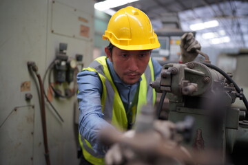 Male engineer metalworker industrial experienced operator technician worker in safety hard helmet working on lathe machine, professional man in industry technology manufacturing factory workshop