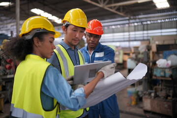 Portrait of Professional Heavy Industry Engineer / Worker Wearing Safety Uniform, Goggles and Hard Hat. In the Background Unfocused Large Industrial Factory
