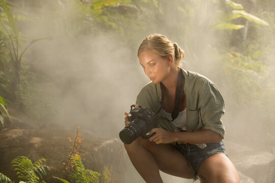 portrait of nice young woman is taking picture in the jungle