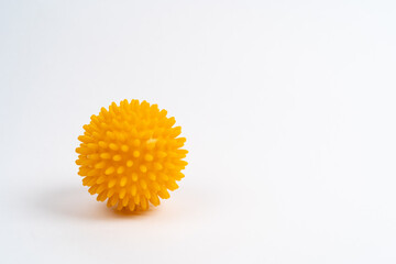 yellow ball of a massage needle on a white background, the concept of prevention of flat feet,...