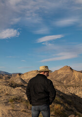 Adult man in cowboy hat standing against mountains in Tabernas desert. Almeria, Spain